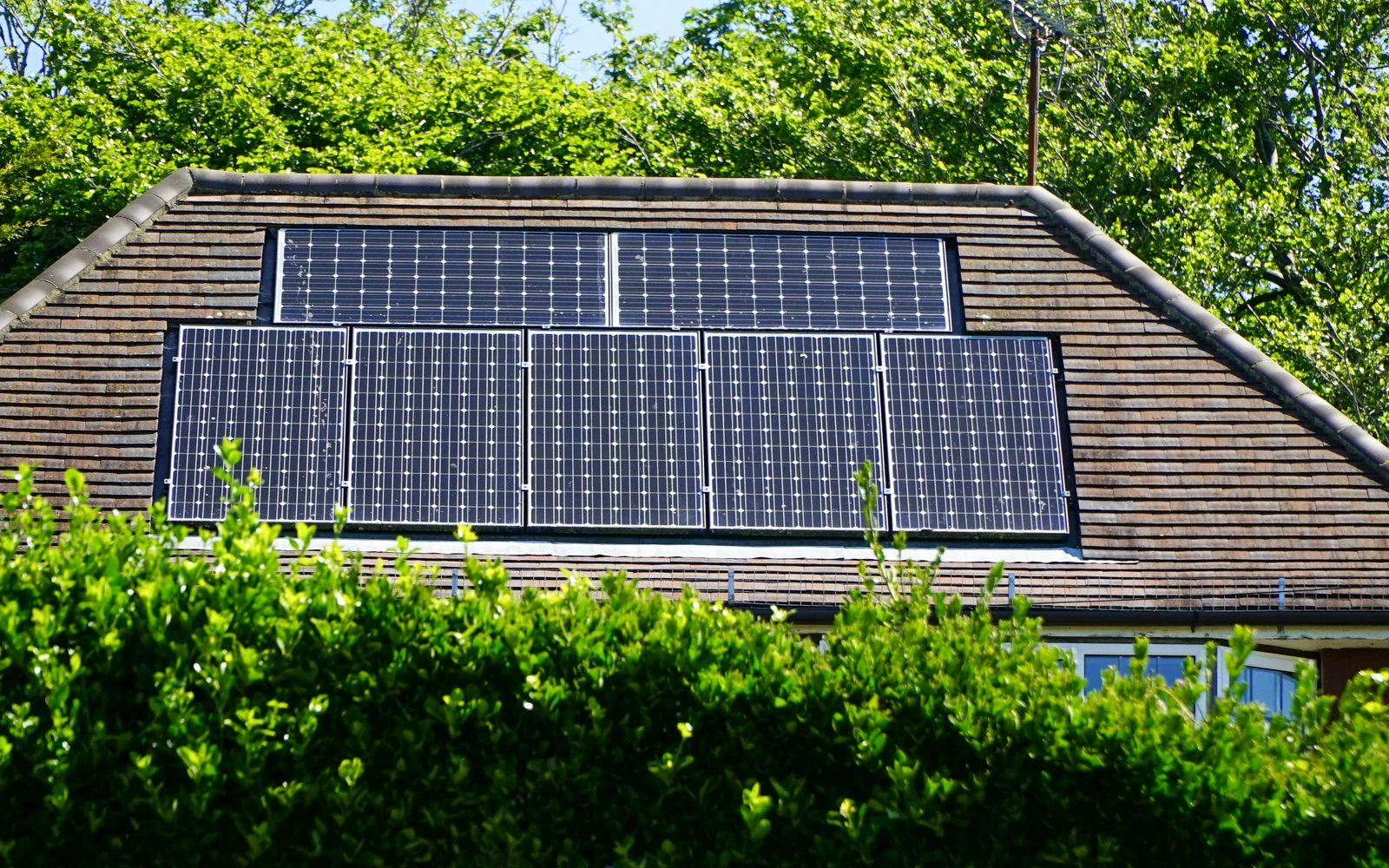 Toiture solaire résidentielle Panneaux photovoltaïques intégrés à la toiture d'une maison entourée de verdure